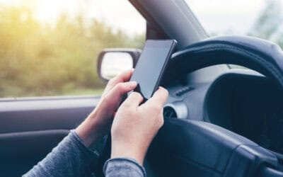 Woman simultaneously driving car and typing text message